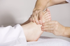 Person lying down receiving a foot massage to the souls of their foot