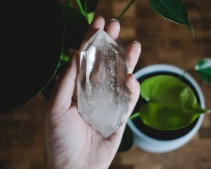 Palm sized white cloudy healing crystal being held